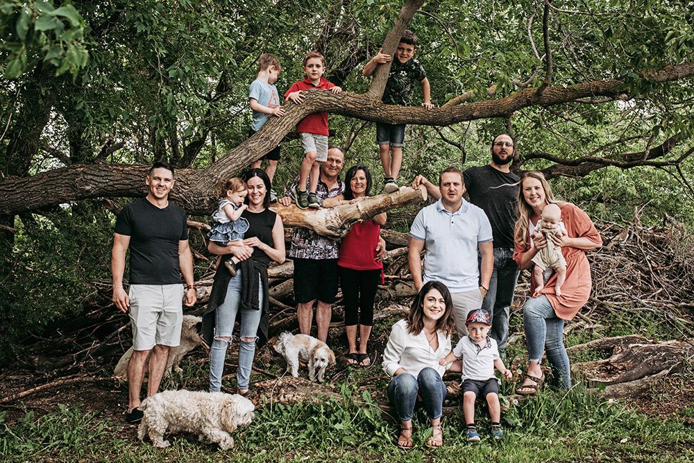 The Badinski families gathered around a fallen tree on the family farm