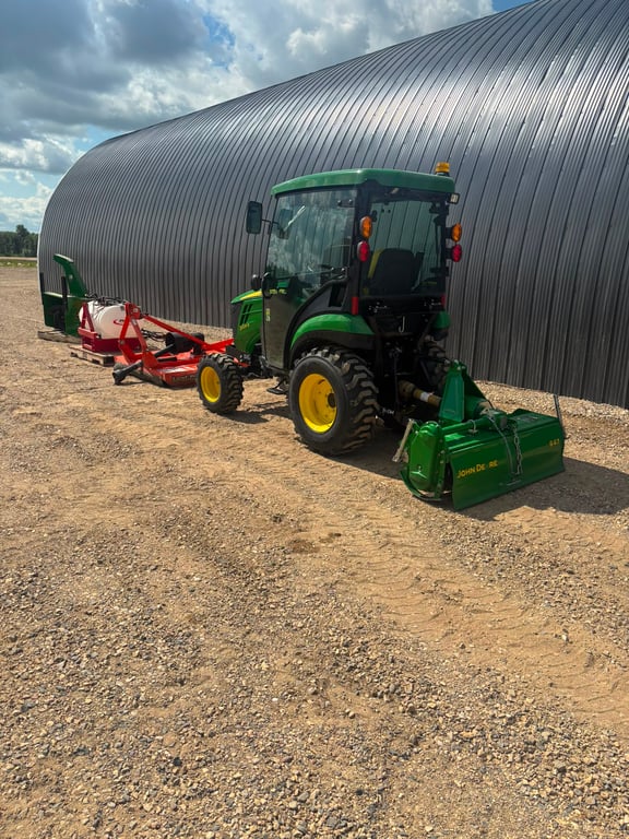John Deere compact tractor with mower and attachments