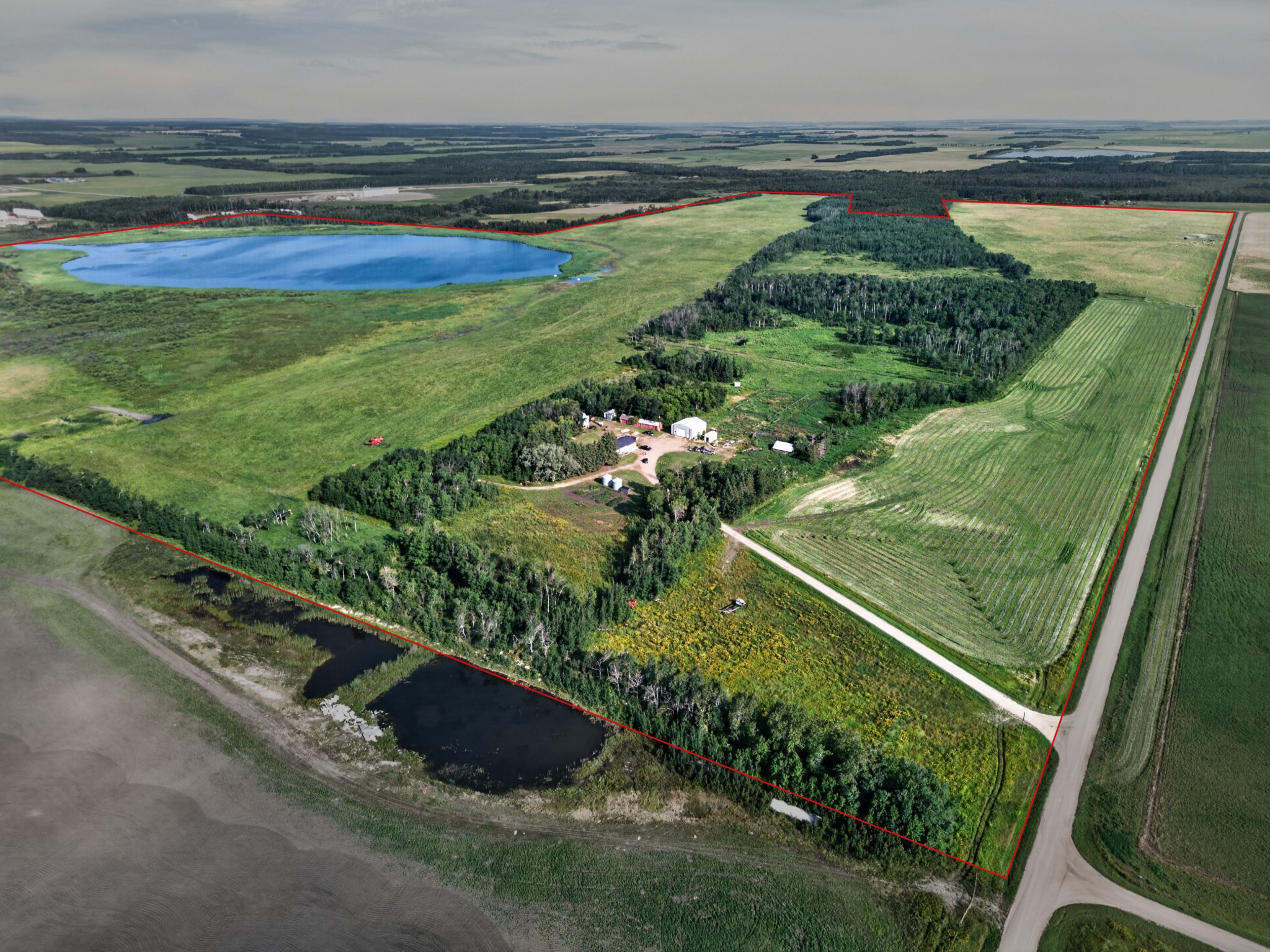 Aerial view of the Lefebvre land with all three quarters outlined, yard site and lake beyond