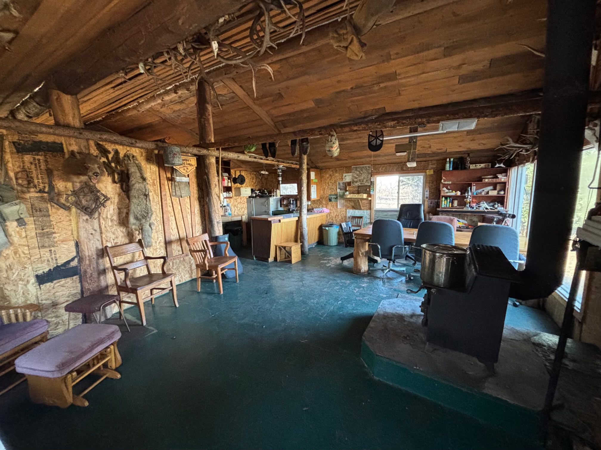 Interior of rustic wooden cabin with kitchen area and tables