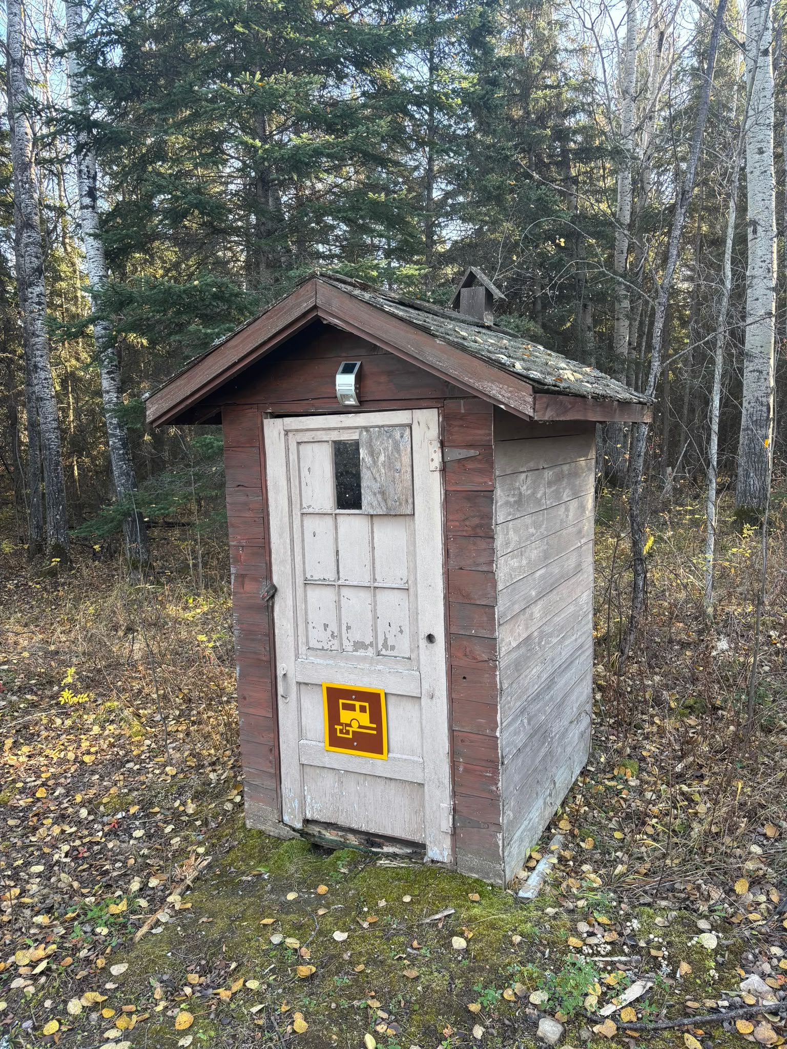 Wooden outhouse in forest setting
